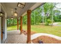Inviting front porch with brick flooring, timber columns, and lantern lighting at 1709 Eastside Parc St, Atlanta, GA 30316