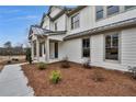Beautiful modern farmhouse-style home with covered porch, white siding, and dark trim and a manicured yard at 1697 Eastside Parc St, Atlanta, GA 30316