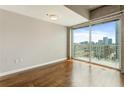Sun-lit bedroom featuring hardwood floors, a modern ceiling light, and a balcony with stunning city views at 361 17Th Nw St # 1001, Atlanta, GA 30363