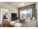 Modern living room with city views, a plush white sofa, sleek furnishings, and a glimpse into the bedroom at 361 17Th Nw St # 1001, Atlanta, GA 30363
