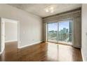 Bright living room with hardwood floors, access to a balcony with city views, and an open doorway at 361 17Th Nw St # 1001, Atlanta, GA 30363