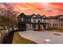 Striking two-story home featuring a brick and dark siding exterior and expansive driveway and manicured yard at 159 Shadburn Ferry Rd, Buford, GA 30518