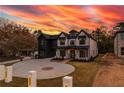Striking two-story home featuring a brick and dark siding exterior and expansive driveway at 159 Shadburn Ferry Rd, Buford, GA 30518