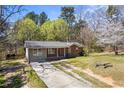 A charming single-story house, with a brick and siding exterior, accented by green lawn and trees at 2420 Green Rd, Loganville, GA 30052