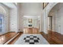 Spacious foyer with hardwood floors, black and white tile inlay, and white trim leading to the living room at 940 Waters Reach Ct, Alpharetta, GA 30022