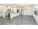 Bright kitchen featuring gray wood floors, white cabinets, a large island and stainless steel appliances at 1176 Red Oak Blvd, Loganville, GA 30052