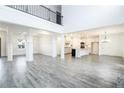Open concept living room and kitchen with gray wood floors, white walls and trim, and a two story ceiling at 1176 Red Oak Blvd, Loganville, GA 30052