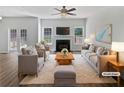 Bright living room with fireplace, ceiling fan, modern furniture, and french doors to the outside at 200 Eagle Glen Ct, Woodstock, GA 30189