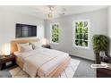 Cozy bedroom with a bed, TV, nightstands, and large windows offering bright, natural light at 200 Eagle Glen Ct, Woodstock, GA 30189