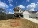 Charming two-story home with white siding, stone accents, a two-car garage and a cozy second-floor balcony at 151 Sunshower Rdg, Canton, GA 30114