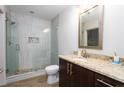Modern bathroom featuring glass-enclosed shower, neutral tile, and granite vanity at 1080 Peachtree Ne St # 1408, Atlanta, GA 30309