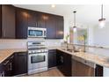 Modern kitchen featuring stainless steel appliances, granite countertops, dark wood cabinets, and pendant lighting at 1080 Peachtree Ne St # 1408, Atlanta, GA 30309