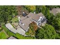 A view of a beautiful home with a manicured lawn, mature trees, and a pergola in a private backyard at 980 Fenimore Cir, Sandy Springs, GA 30350