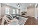 Comfortable living room featuring a stone fireplace, hardwood floors and three large windows at 2423 Rosapenna Nw Ln, Kennesaw, GA 30152
