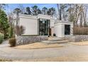 Modern home with a stone wall, steps, and a two story glass entrance, providing an eye-catching focal point at 3184 Wood Valley Nw Rd, Atlanta, GA 30327