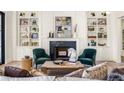 Elegant living room with fireplace, built-in shelves, and sophisticated decor with green accent chairs at 3290 Dunlop Ne Ct, Brookhaven, GA 30319