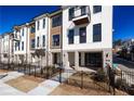 Charming townhome featuring a modern facade, complemented by black trim, a gated yard, and manicured landscaping at 348 Olmstead Way # 30, Alpharetta, GA 30022