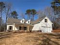White two-story house with gray roof, stone accents, and a two-car garage at 90 Hammock Dr, Covington, GA 30016