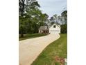 Charming home with a lush green lawn and a long driveway leading to the two-car garage at 90 Hammock Dr, Covington, GA 30016