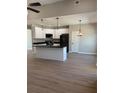 Kitchen area with white cabinets, an island, black appliances, and wood floors at 90 Hammock Dr, Covington, GA 30016