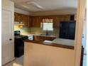 Kitchen with stainless steel sink, black appliances, wood cabinets and peninsula seating at 430 Poole Bridge Rd, Hiram, GA 30141