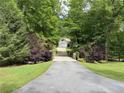 Long driveway leading to a home, framed by meticulously maintained landscaping and mature trees at 6054 Nebo Rd, Hiram, GA 30141