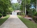 Long driveway leading to a home surrounded by lush greenery and mature trees, creating a private setting at 6054 Nebo Rd, Hiram, GA 30141