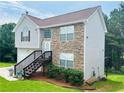 Two-story house with stone and siding accents, attached garage, and steps leading to the front entrance at 4118 Lost Springs Trl, Douglasville, GA 30135