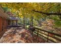 Spacious wooden back deck overlooking serene wooded backyard with autumn leaves and a grill at 810 Mcconnell Rd, Powder Springs, GA 30127