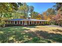 Charming brick home with white trim, complemented by a lush green lawn and mature trees at 810 Mcconnell Rd, Powder Springs, GA 30127