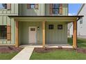 Inviting covered front porch framed with sturdy wooden posts, offering a cozy entrance to the light green home at 38 Puckett Se Rd, Emerson, GA 30137