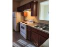 Functional kitchen with an electric range oven and dark wood cabinetry at 424 Village Way, Loganville, GA 30052