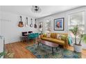 Living area featuring hardwood floors, mustard-colored sofa, and guitar wall decor at 764 Edgewood Ne Ave # 1, Atlanta, GA 30307