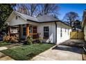 White bungalow with a spacious front yard and driveway at 1110 Mcdaniel Sw St, Atlanta, GA 30310
