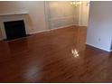 Spacious living room with a fireplace, gleaming hardwood floors, and natural light at 6579 Alford Way, Lithonia, GA 30058