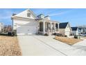 Attractive home featuring a spacious driveway, a covered porch and meticulous landscaping at 5810 Collier Bridge Ln, Hoschton, GA 30548