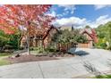 Beautiful home showcasing brick, stone and mature trees on a large lot and circular driveway at 879 Big Horn Hollow, Suwanee, GA 30024
