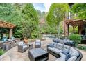 Spacious stone patio with outdoor seating, a built-in grill, and a pergola overlooking the pool at 879 Big Horn Hollow, Suwanee, GA 30024