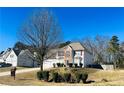 Two-story home with a long driveway, two-car garage, and a manicured front lawn under a clear blue sky at 2717 Kristen Ct, Conyers, GA 30012