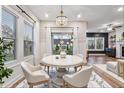 Bright dining room with a modern chandelier and natural light from large windows at 802 Oak Promenade Ln, Canton, GA 30115