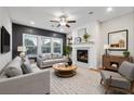 Cozy living room featuring a fireplace, ceiling fan, and comfortable seating at 802 Oak Promenade Ln, Canton, GA 30115