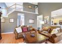 Spacious living room with hardwood floors, leather sofas, and a large window at 3559 Gus Way, Powder Springs, GA 30127