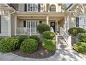 Inviting front porch with manicured hedges, white railings and steps, offering a warm welcome to the home at 1400 Lamont Cir, Dacula, GA 30019