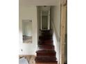 View of a wooden stairway featuring a reflective mirror leading to the upstairs hall at 3230 Vanderbilt Nw Ln, Atlanta, GA 30318