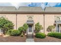 Brick townhouse with a gray roof and landscaping at 6980 Roswell Rd # J6, Atlanta, GA 30328