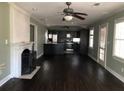 Open-concept living room featuring hardwood floors, a ceiling fan, and a fireplace with a decorative mantle at 148 Murray Hill Ne Ave, Atlanta, GA 30317