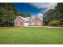 Charming brick home features a metal roof, a spacious lawn, and mature trees at 3598 Brock Rd, Duluth, GA 30096