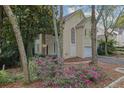 Tan house with a white garage door and pink flowers in the front at 10 Braemore Dr, Sandy Springs, GA 30328