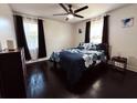 Cozy bedroom with a ceiling fan, dark wood floors, and large windows with dark curtains at 2161 Penelope Nw St, Atlanta, GA 30314