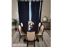 Elegant dining room with an oval table, upholstered chairs, and dark blue curtains at 958 Fellowship Rd, Fairburn, GA 30213